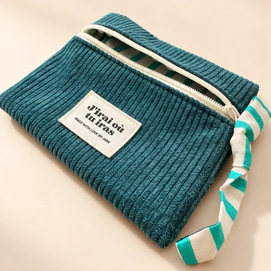 Pochette bleu canard entrouverte sur sa doublure à rayures turquoise, étiquette J’irai où tu iras
