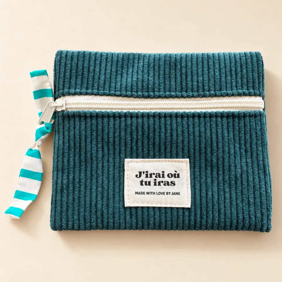 Pochette plate en velours côtelé bleu canard, fermeture écrue, tirette nouée à rayures turquoise, étiquette J’irai où tu iras