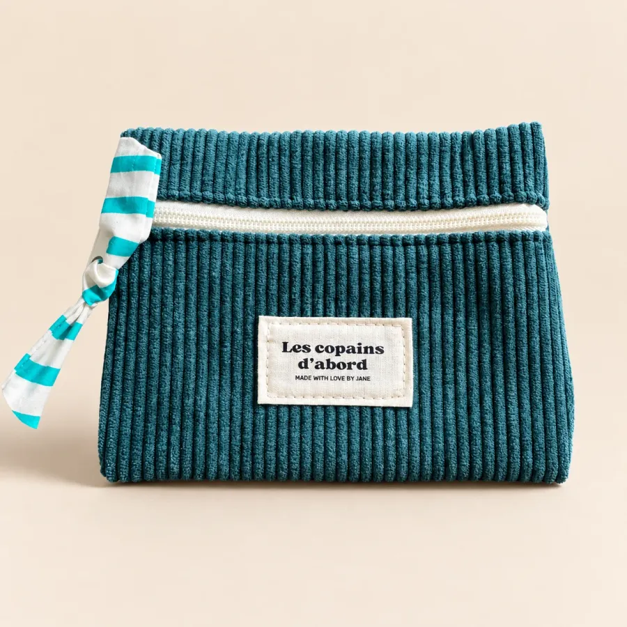 Pochette en velours côtelé bleu canard vue de face, tirette nouée à rayures turquoise, étiquette Les copains d’abord