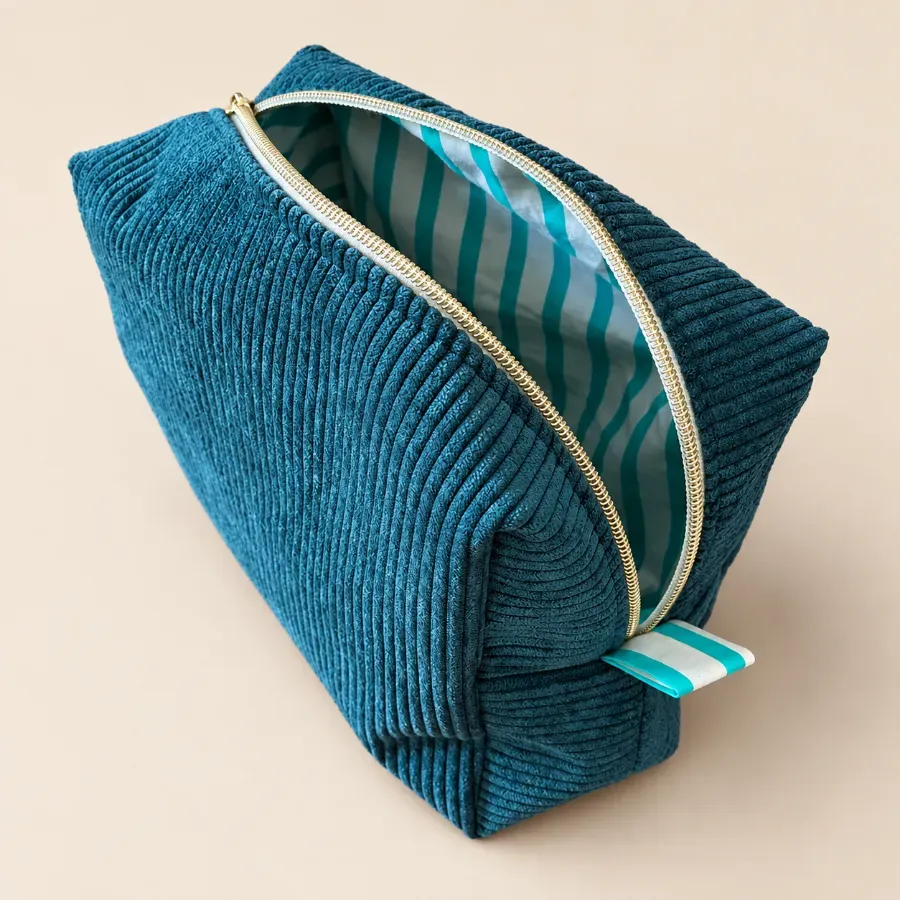 Trousse en velours bleu canard ouverte sur sa doublure rayée